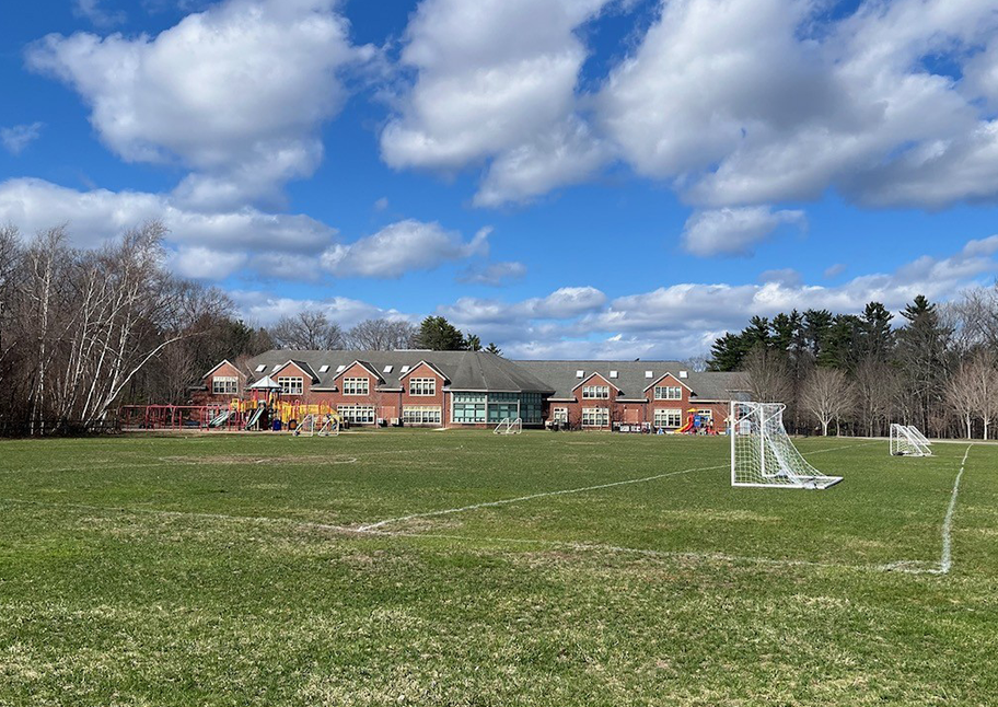 Far away photo of Lunenburg school with clouded blue skies above