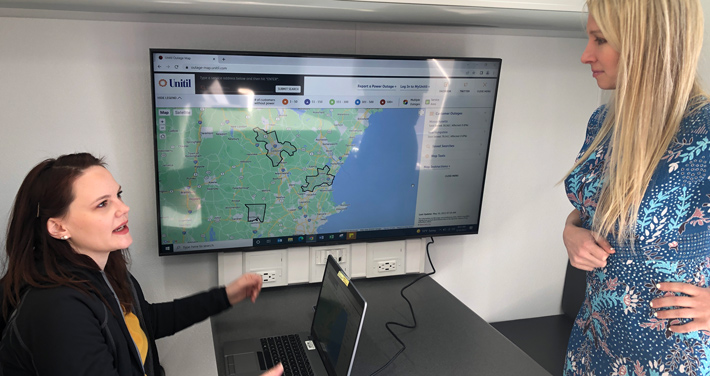 two women review the outage map at mobile command center desk