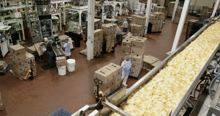 interior of UTZ factory showing workers boxing chips near conveyor belt